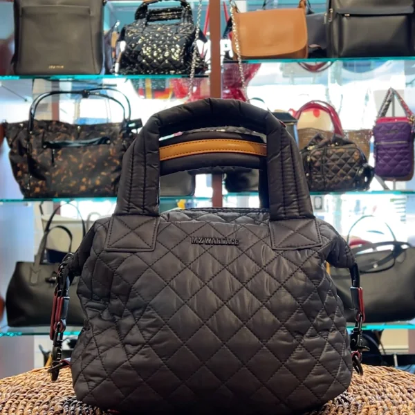 A black quilted MZ Wallace handbag in front of the handbag wall at London Harness
