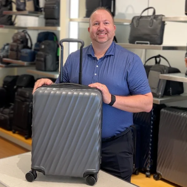 Co-owner holding a grey TUMI 19 Degree carry-on inside TUMI Wellesley